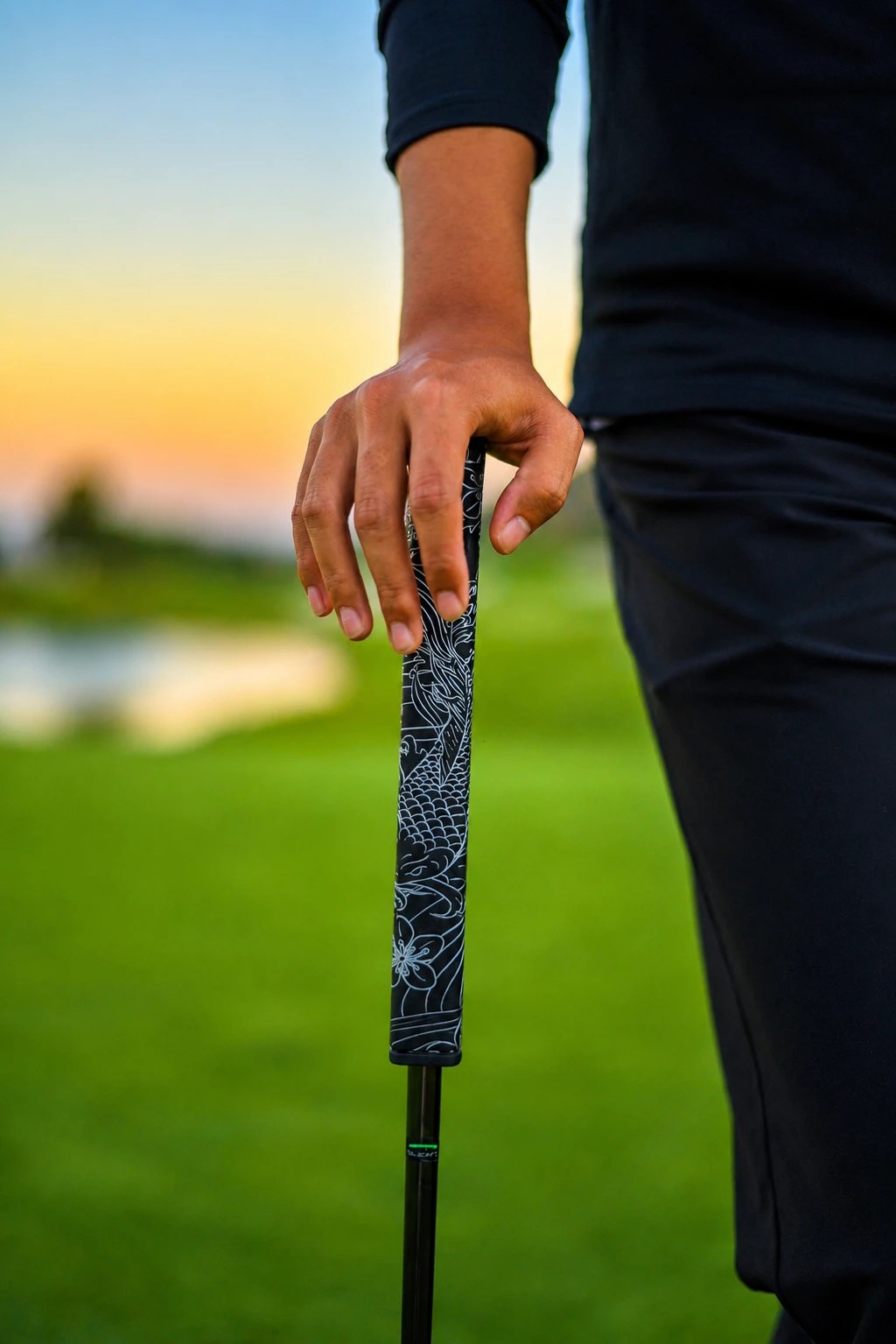 Kaiyen Jewel black and silver koi-engraved putter grip held on the course at golden hour
