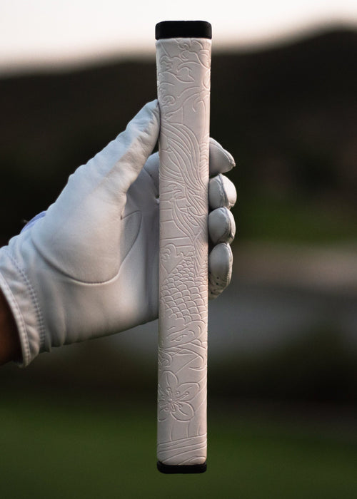 Kaiyen Pearl white koi-engraved putter grip held in a gloved hand